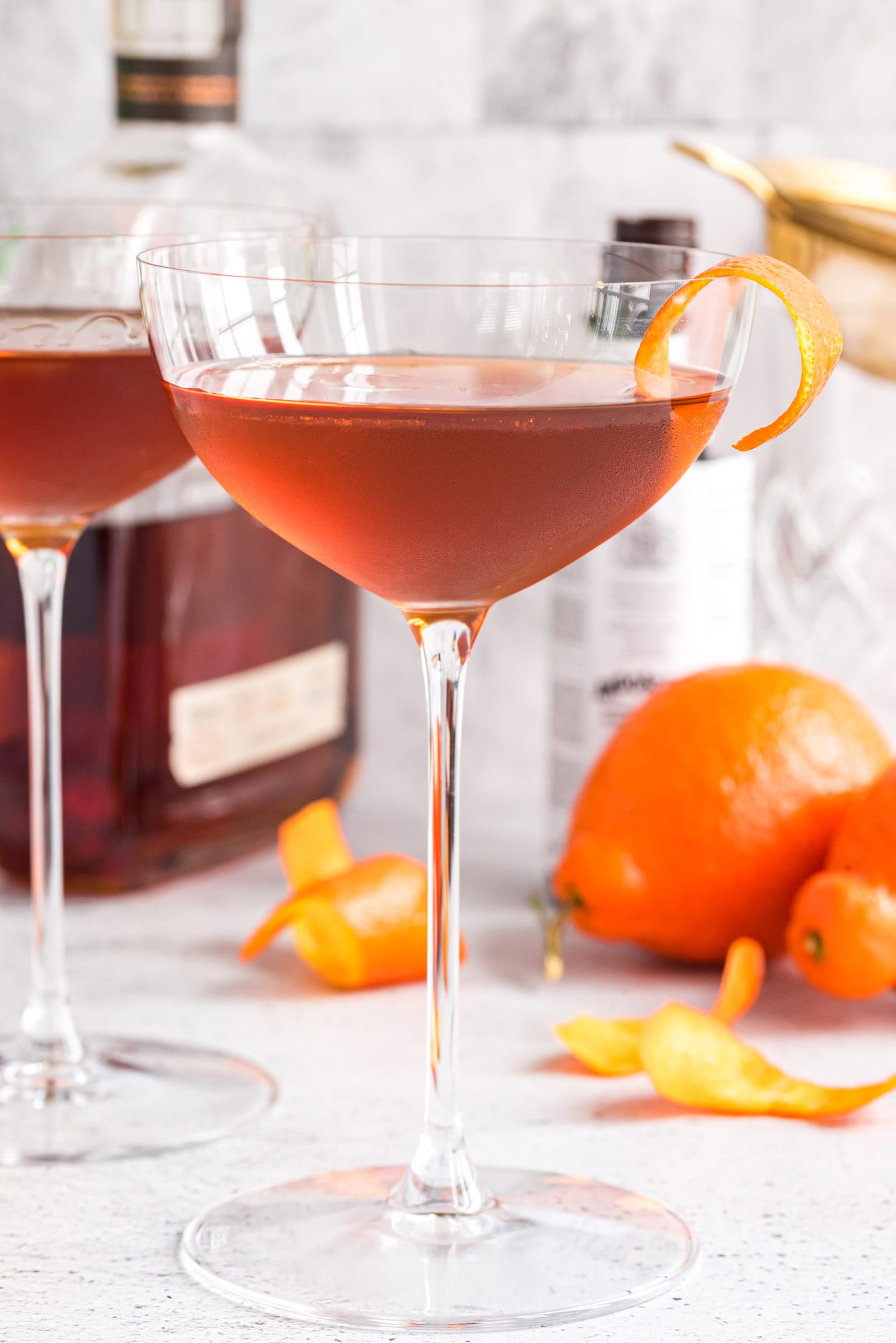 Manhattan Cocktail with liquor bottles in background