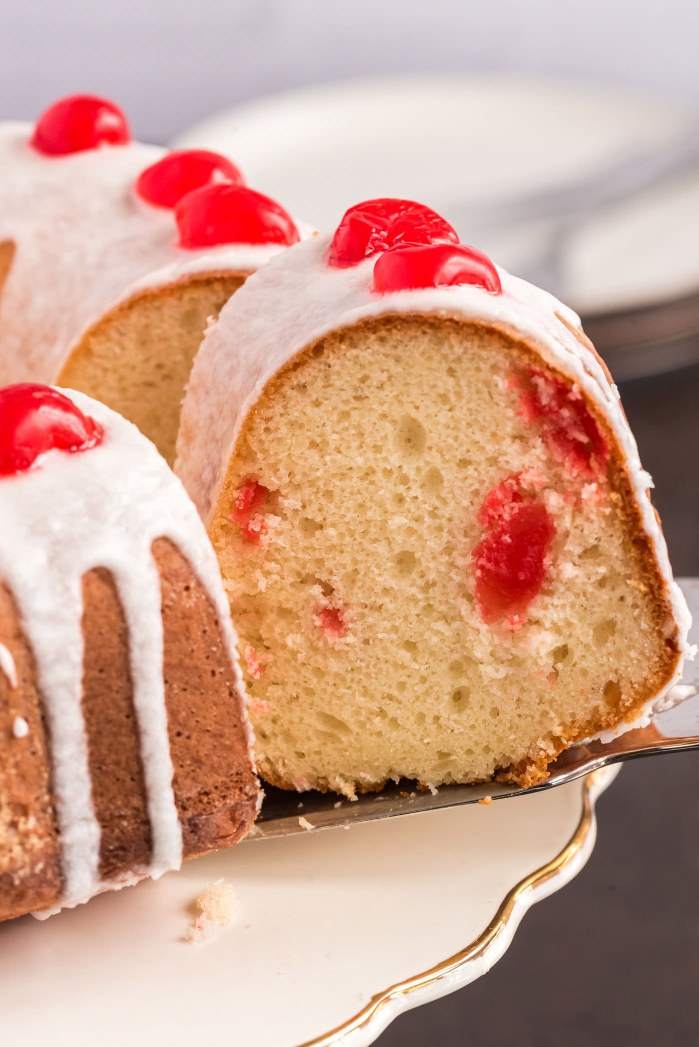 Slice of Maraschino Cherry Bundt Cake being removed from the bundt cake