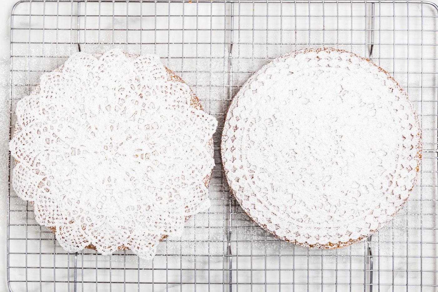 doilies on top of cake and dusted with powdered sugar