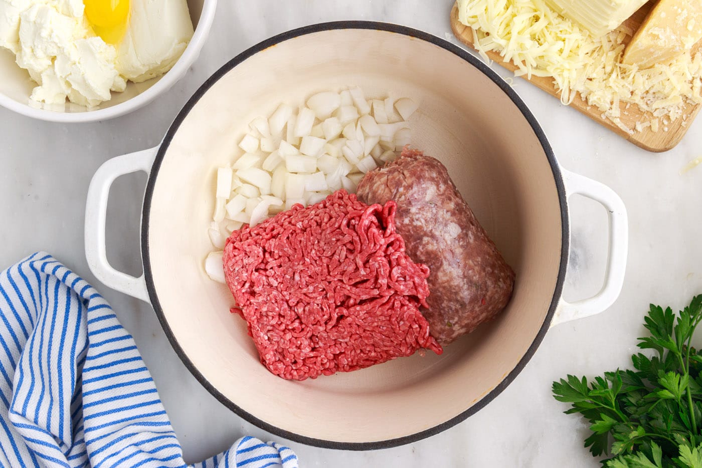 italian sausage and ground beef in a pan with onion