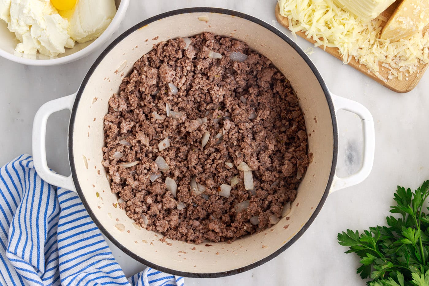 cooked beef and sausage with onion in a skillet