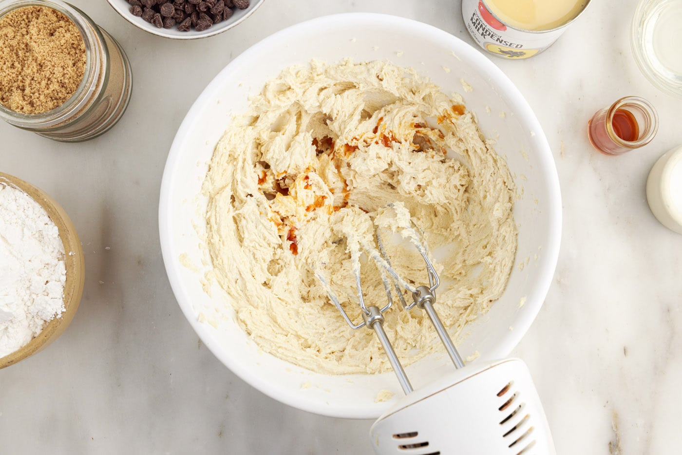 adding vanilla to shortbread crust ingredients in a bowl