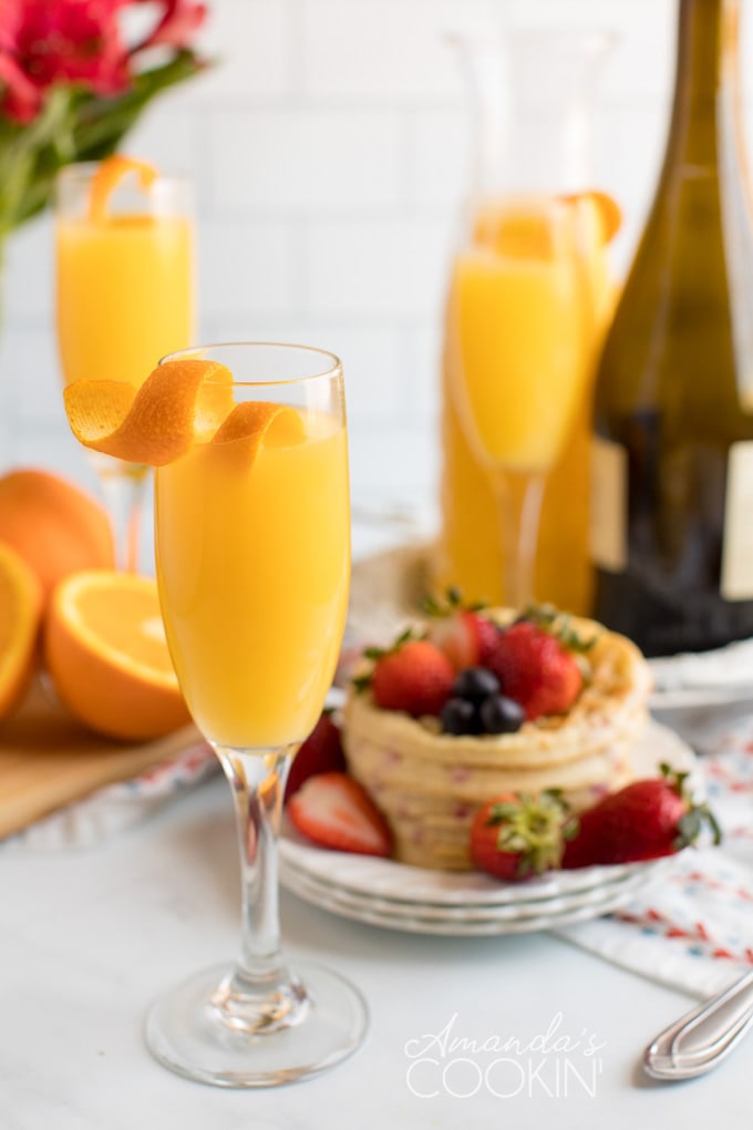 three mimosas with waffles in the background