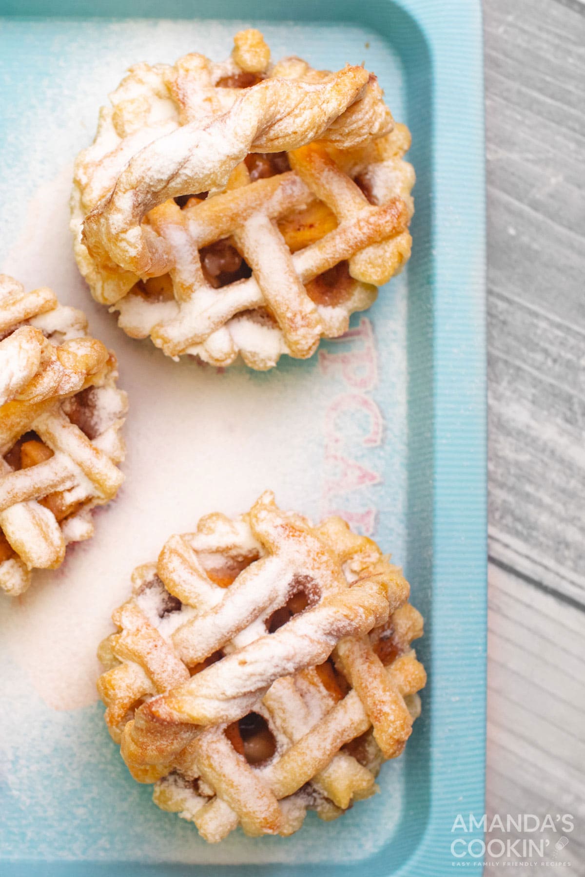 overhead photo of mini apple pies on a blue platter