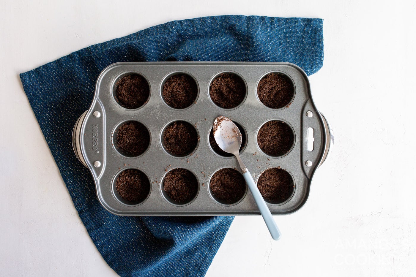 spoon in graham cracker crust into mini muffin pan