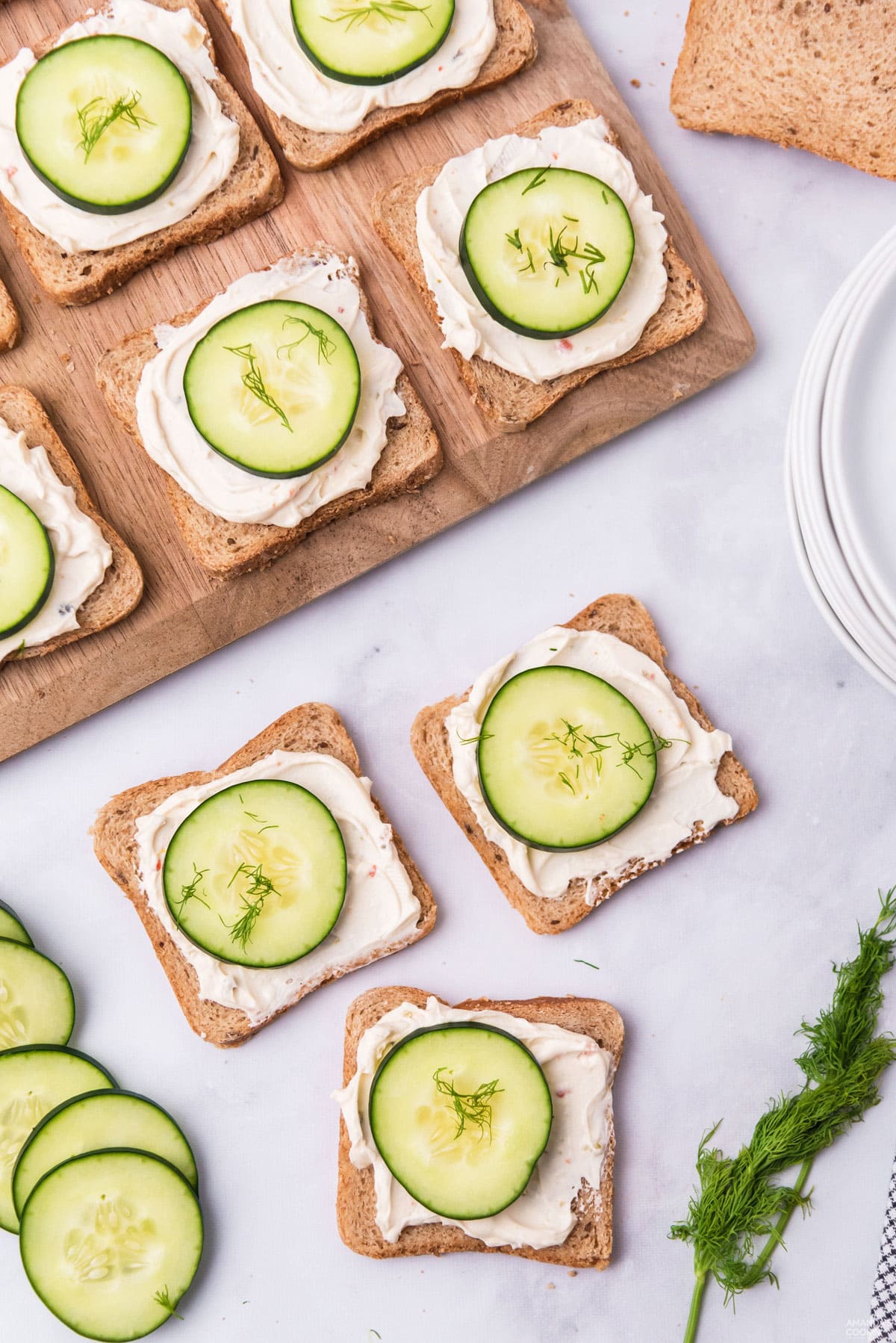 MINI CUCUMBER SANDWICHES ON A WOOD BOARD