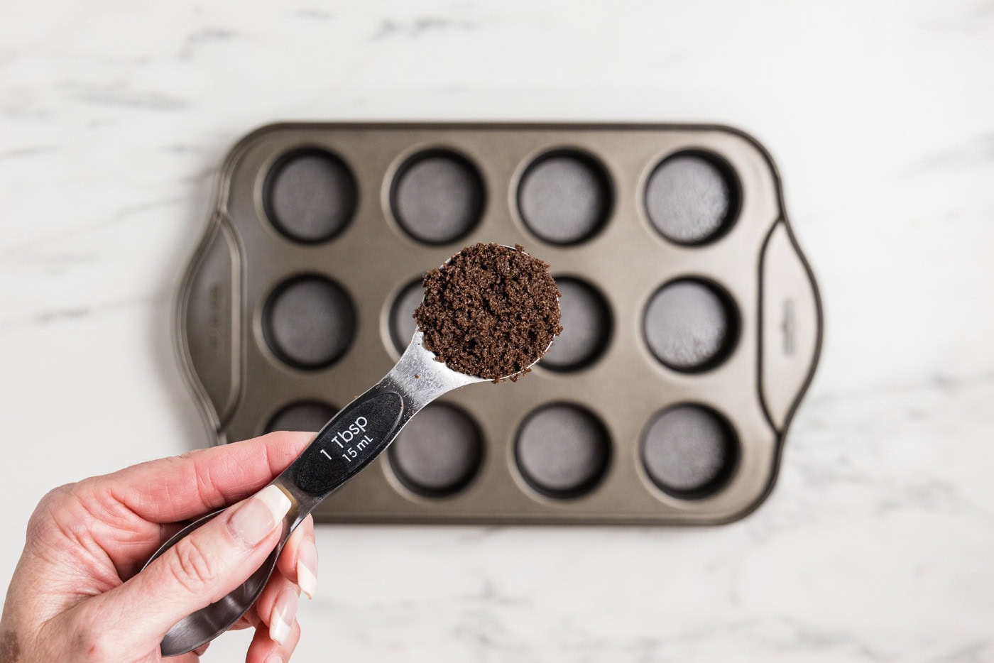 tablespoon of chocolate graham cracker crumbs over mini cheesecake pan