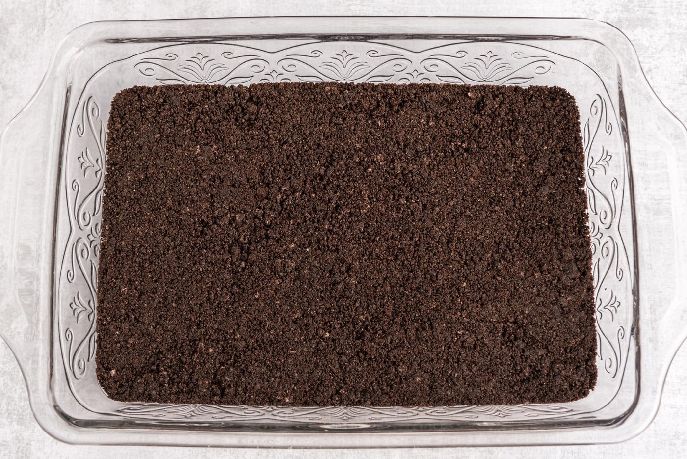 Oreo cookie crust in a baking pan