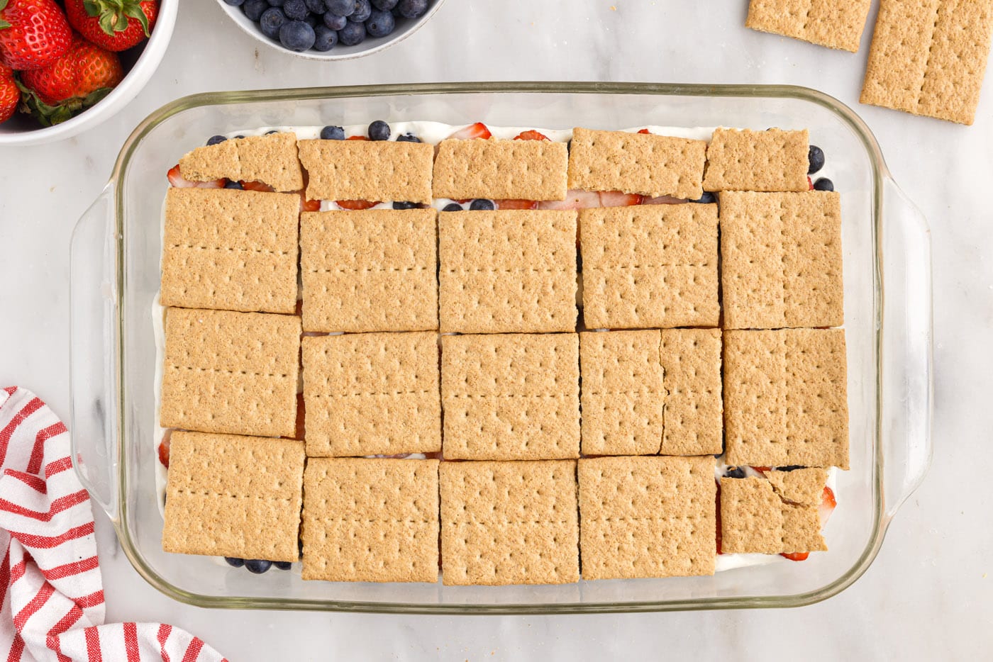 graham crackers layered over berries in a baking dish