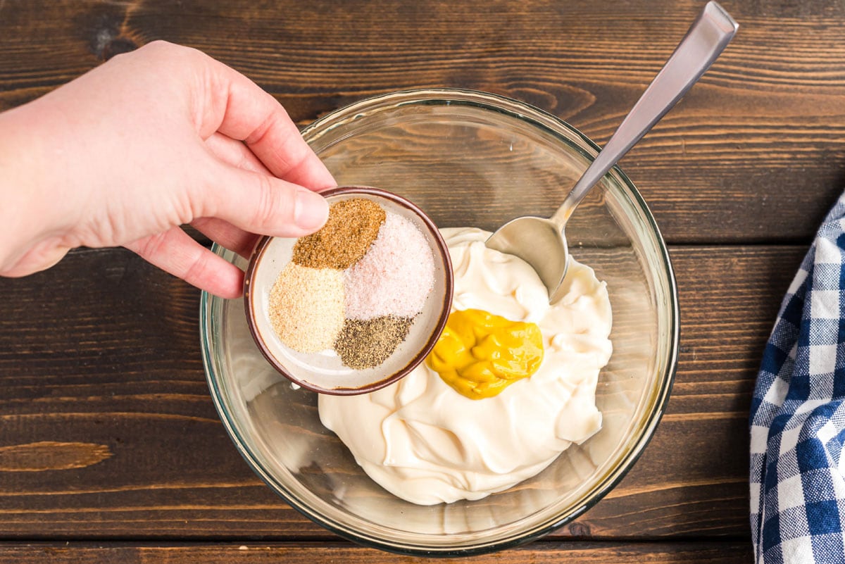 adding seasoning to mayo and mustard