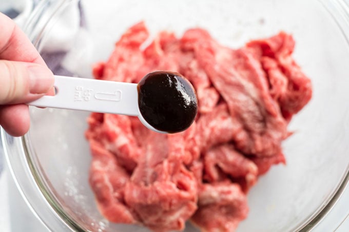 adding hoisin sauce to beef