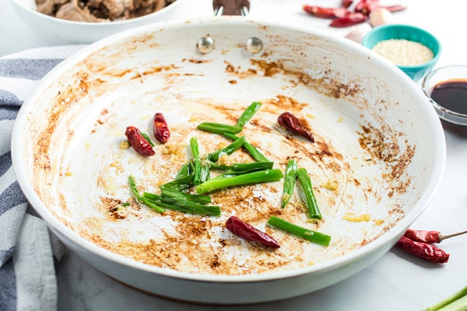 peppers and green onions in a skillet