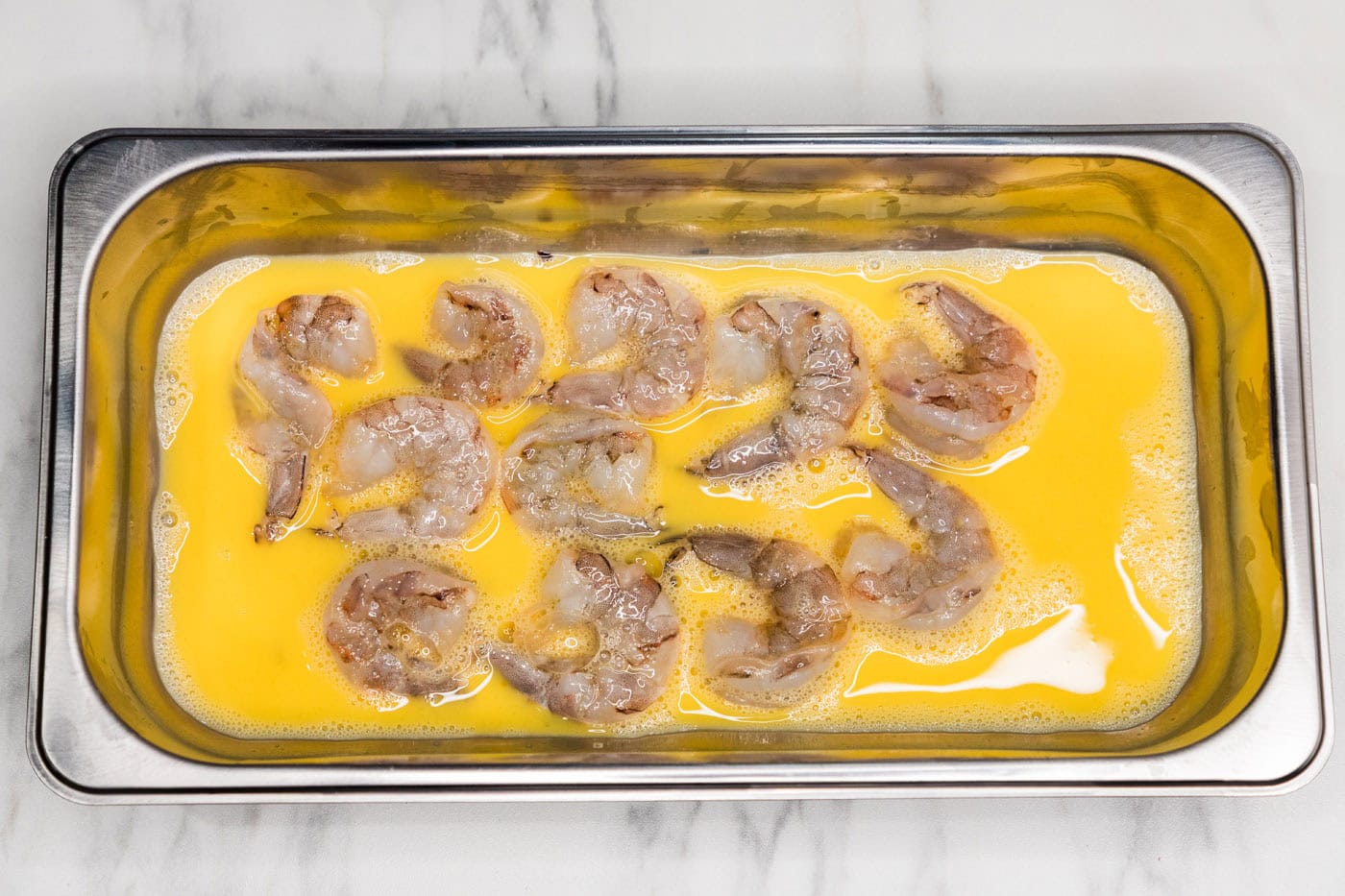shrimp in a breading tray with egg