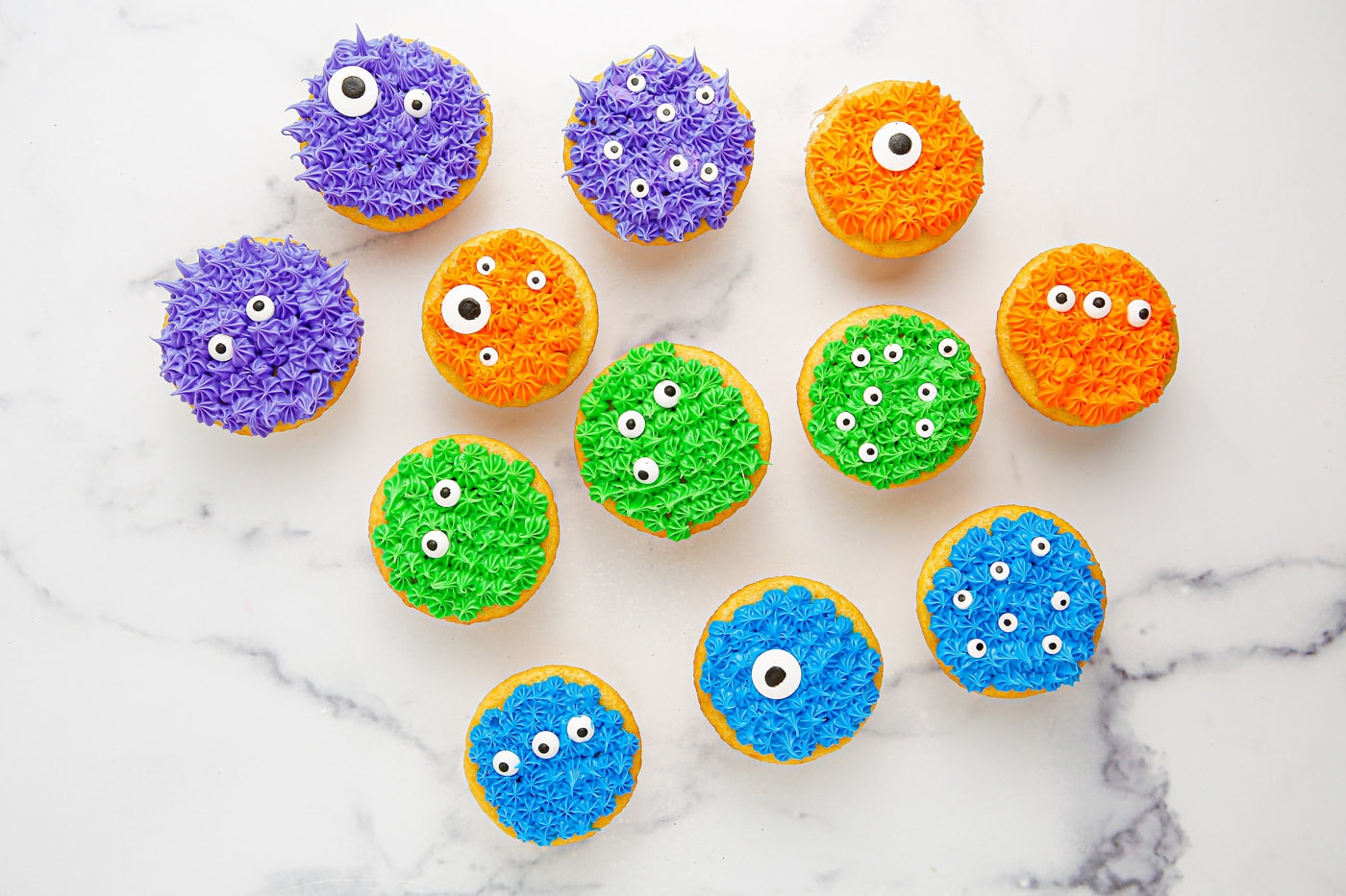 decorating monster cupcakes with frosting and candy eyeballs