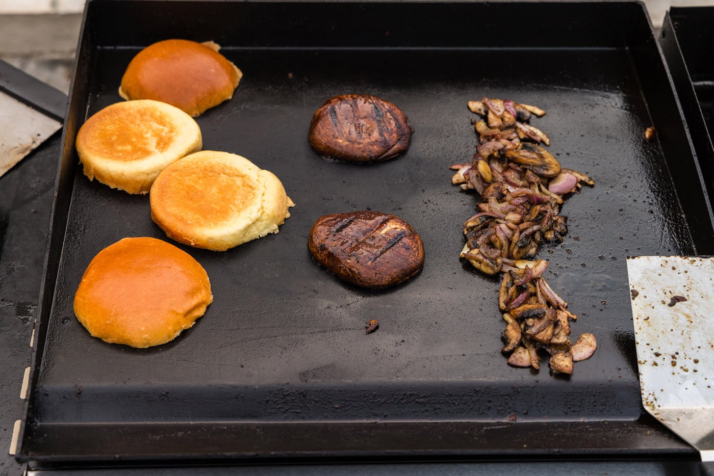sliced mushrooms, burger buns, and portobello mushroom caps on grill grate