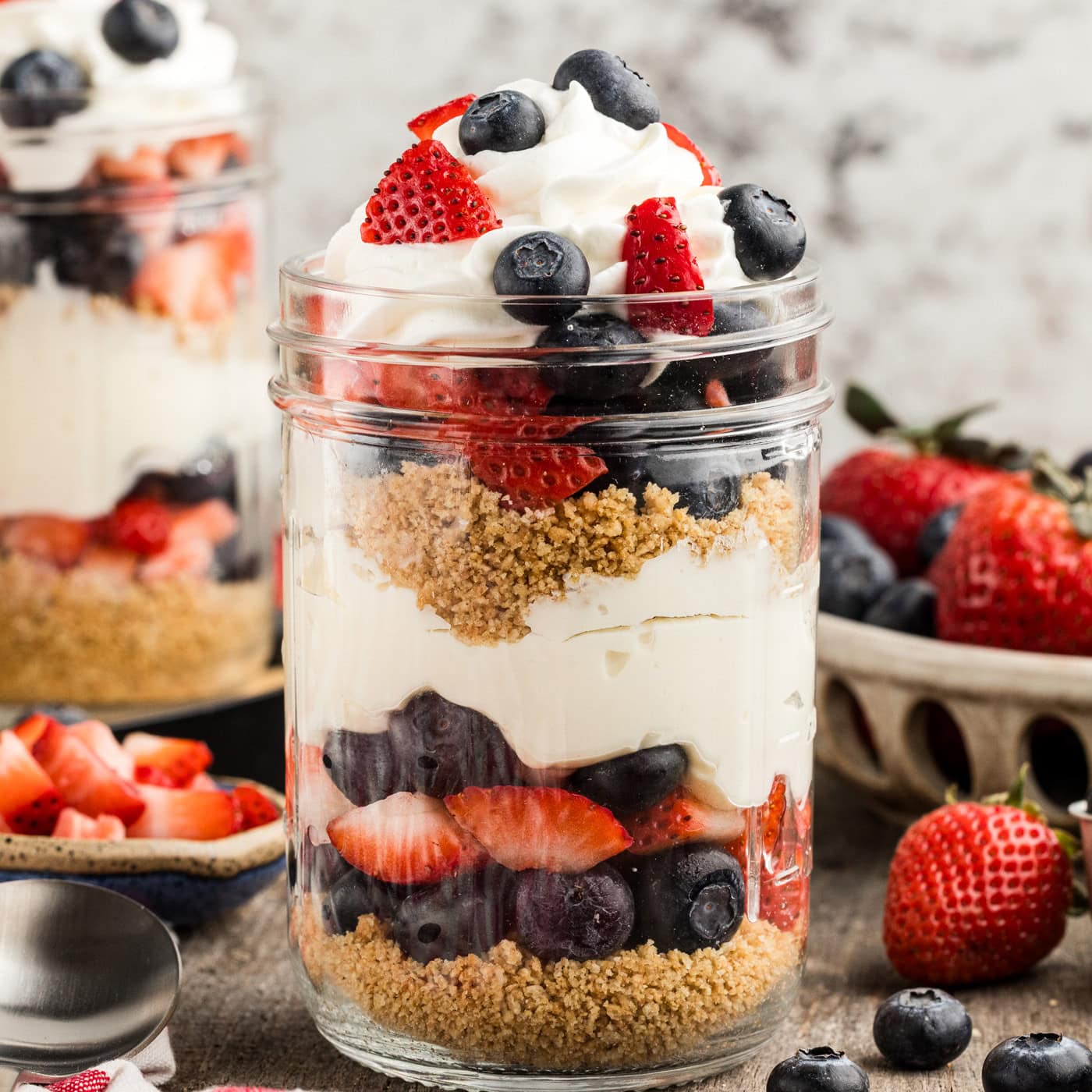 Close up No Bake Berry Cheesecake Trifle in Mason Jars