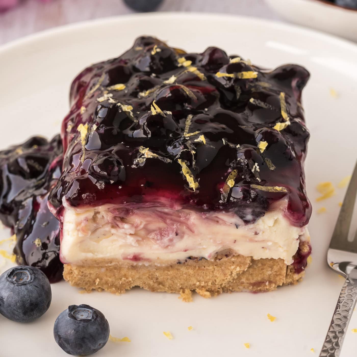 Close up photo of a slice of No Bake Blueberry Cheesecake on a plate