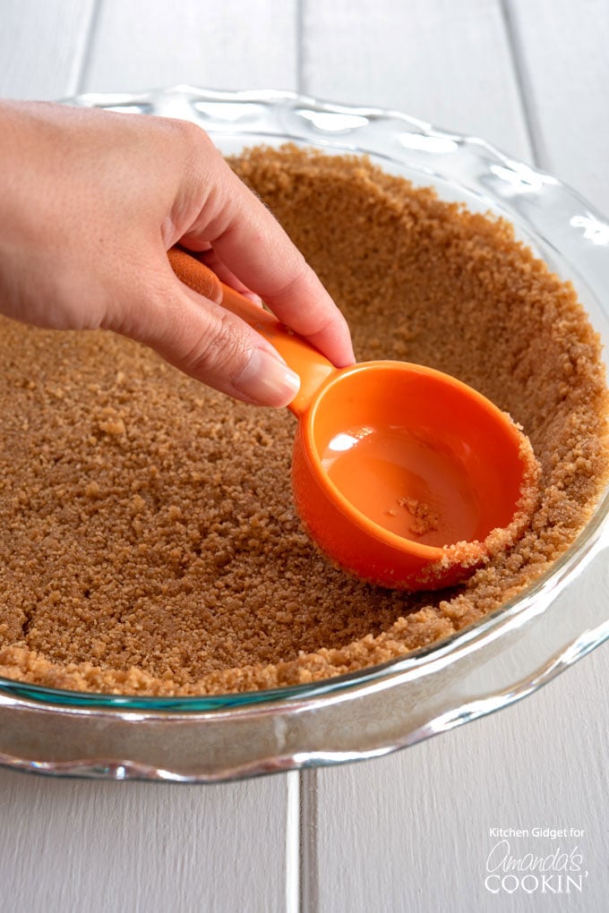 pressing down the graham cracker crust