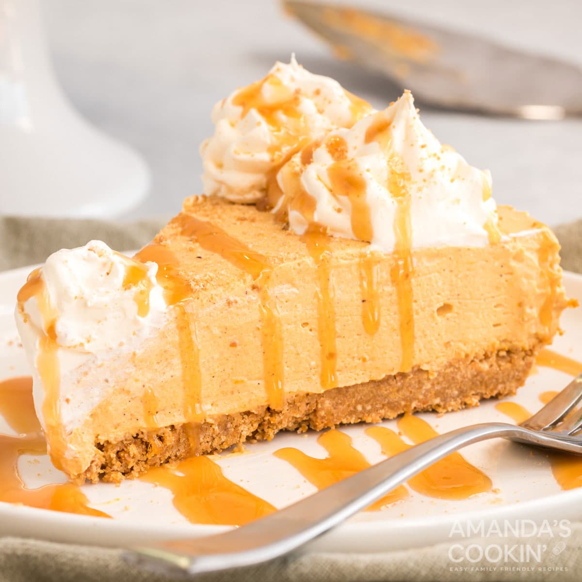 slice of no bake pumpkin cheesecake on a plate drizzled with caramel
