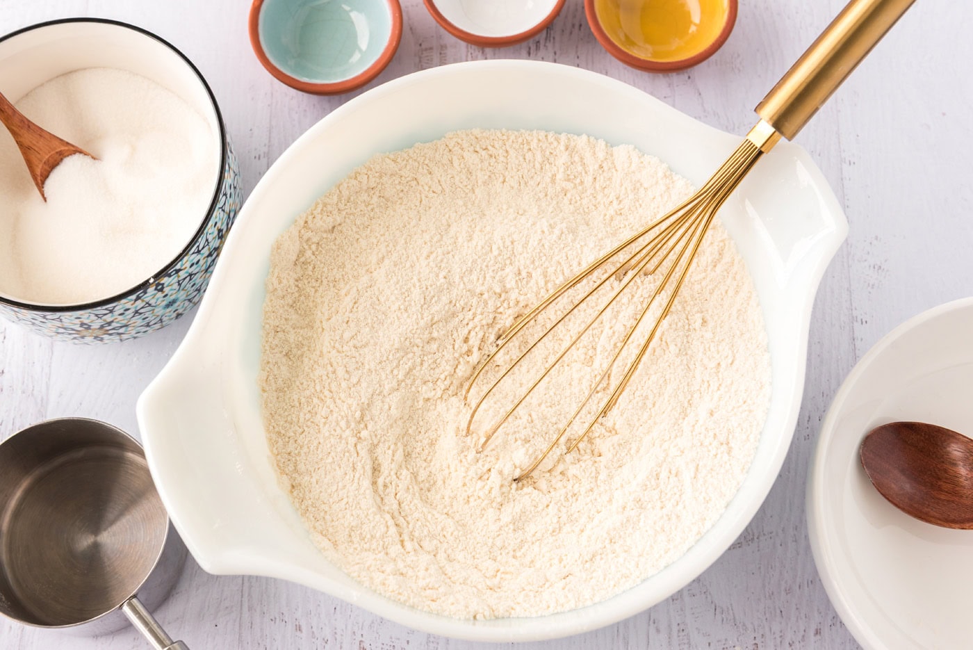 flour, sugar, baking powder, baking soda, and salt whisked in a bowl