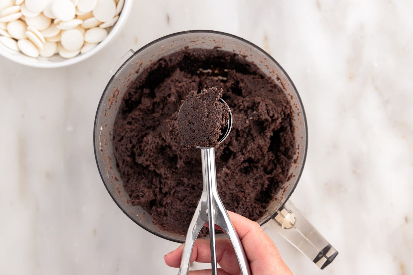 scooping out oreo dough from food processor