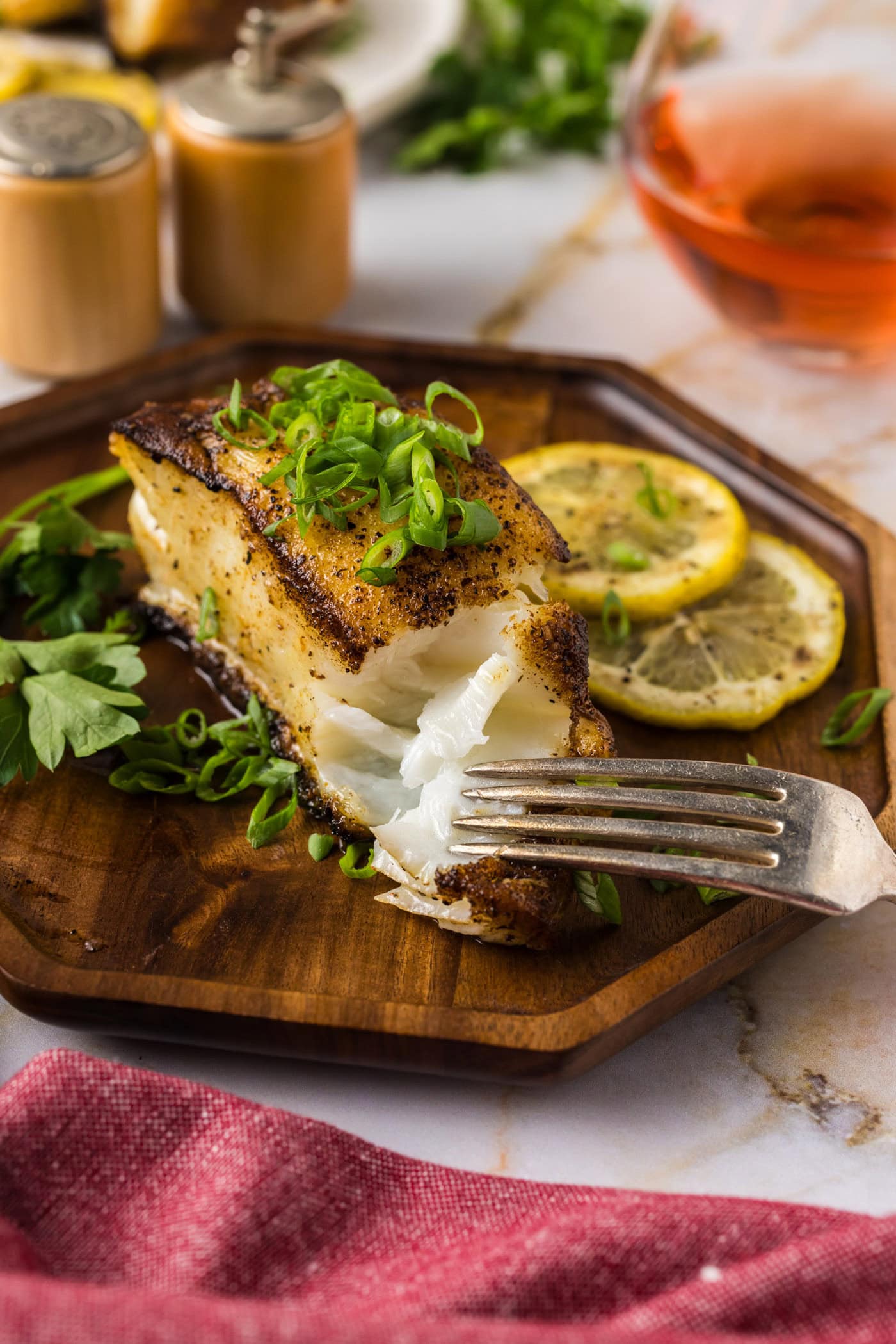 Fork breaking apart a Pan Seared Chilean Sea Bass filet