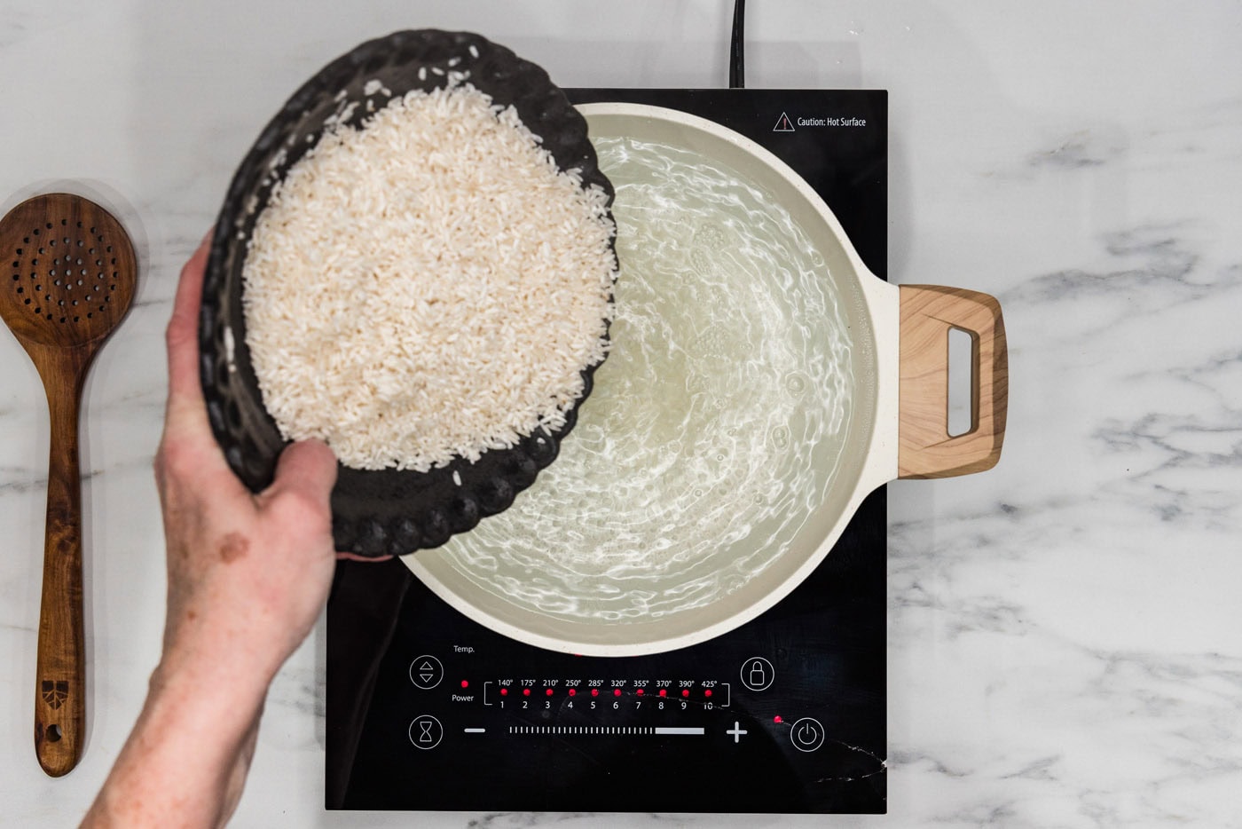 pouring rice into boiling water