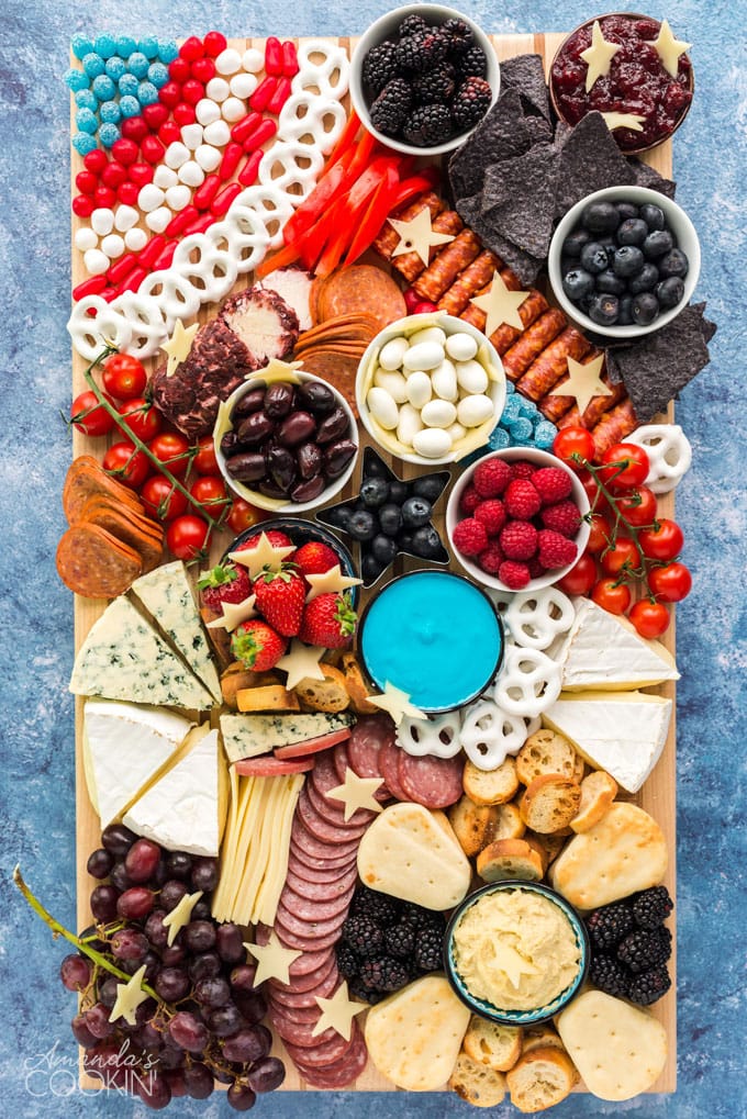 patriotic charcuterie board with tons of finger foods, cheese, crackers, fruit, etc