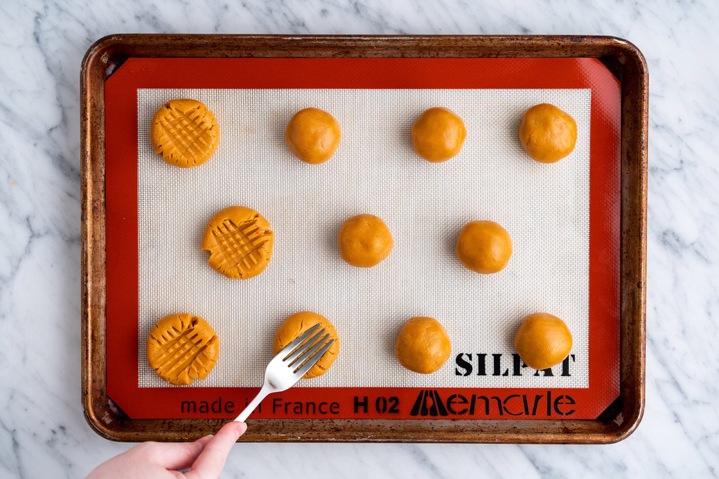 pressing peanut butter cookie dough with a fork