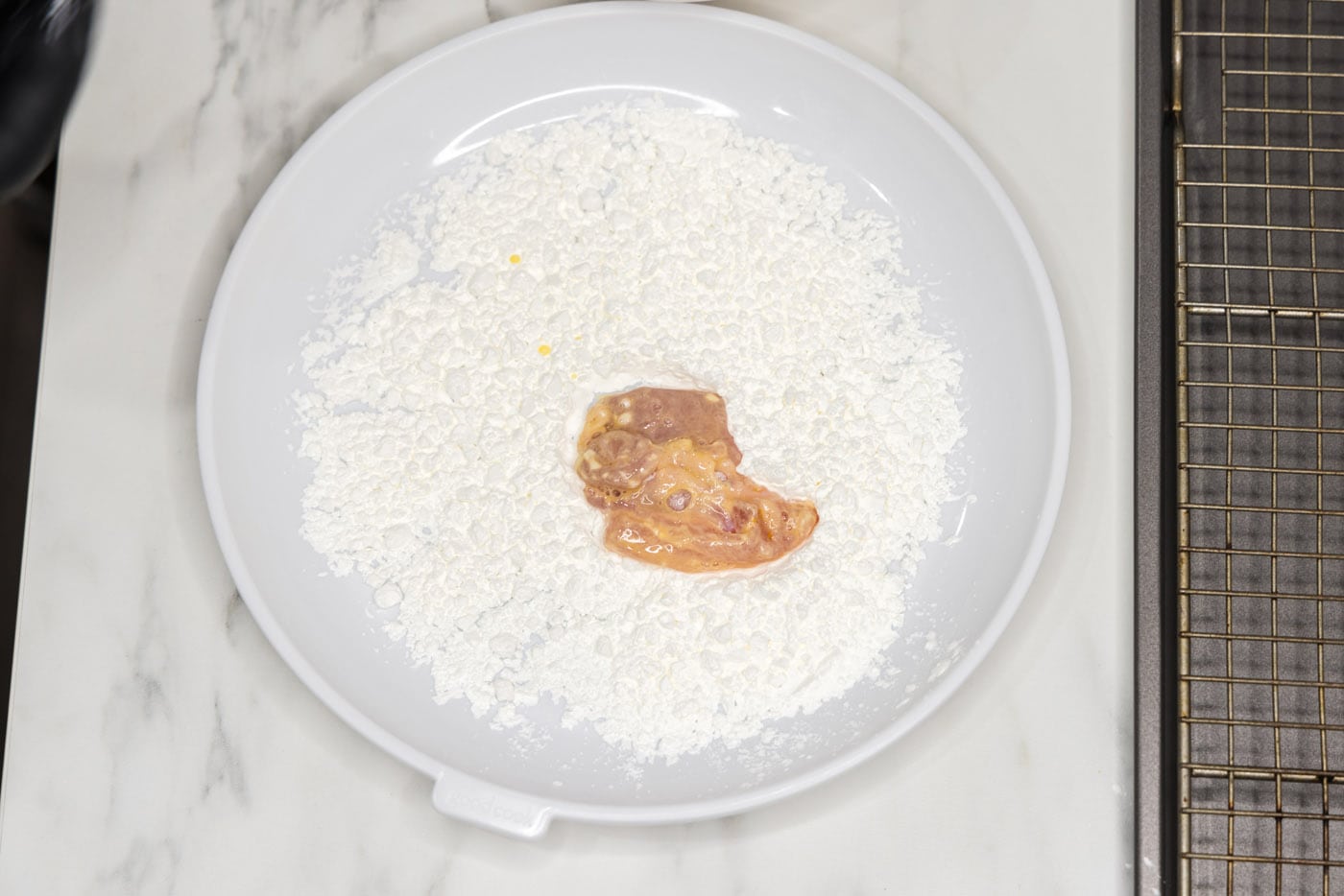 coating chicken piece in cornstarch before frying