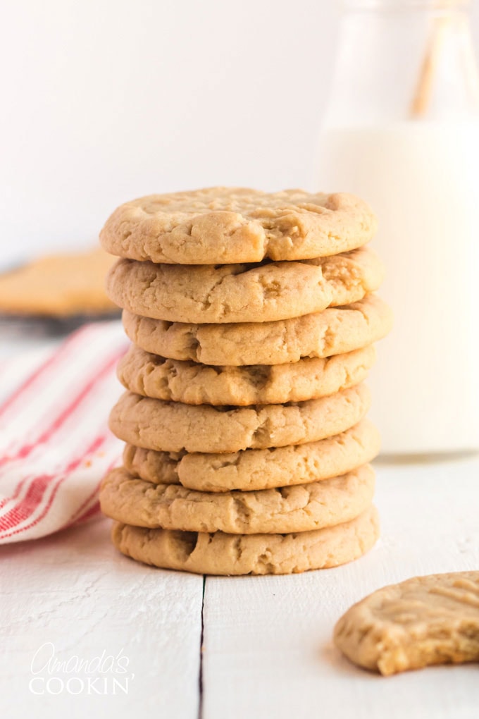 peanut butter cookies stacked with a bottle of milk