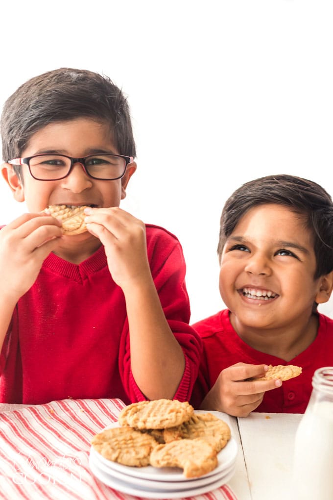 two cute kids eating peanut butter cookies