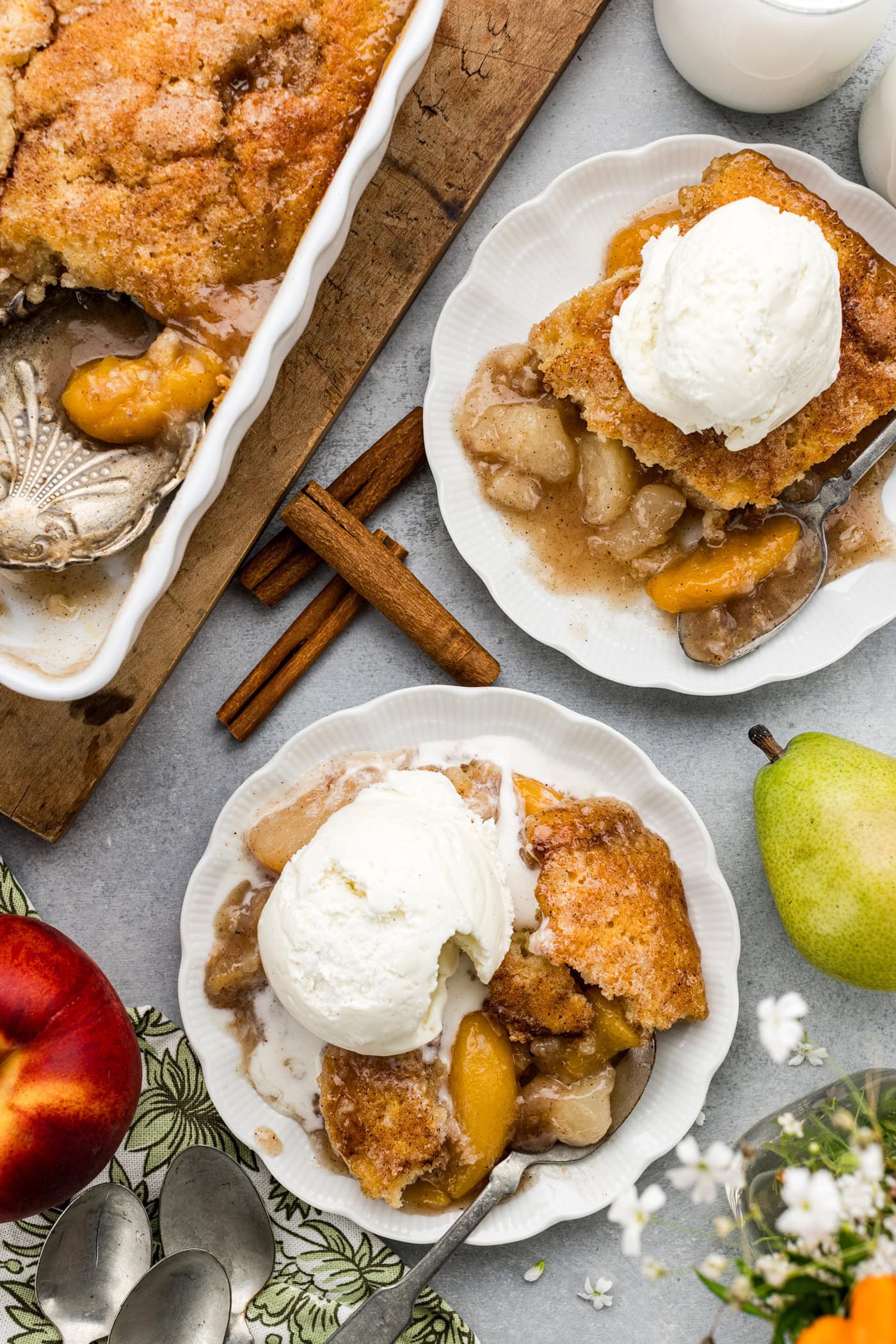 Two plates of Pear-Peach Cobbler topped with ice cream