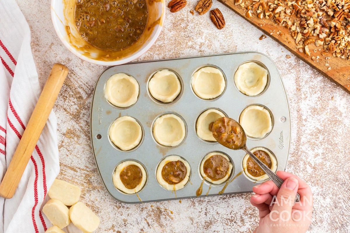 spooning filling into dough in muffin tin