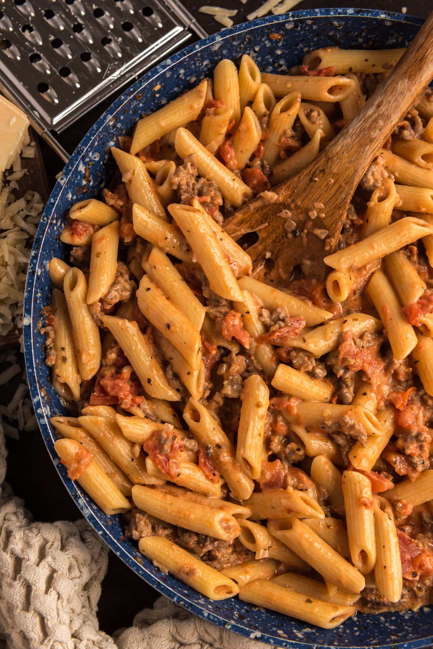 Close up photo of Penne with Tomato Sage Sausage Sauce in a skillet with a spoon