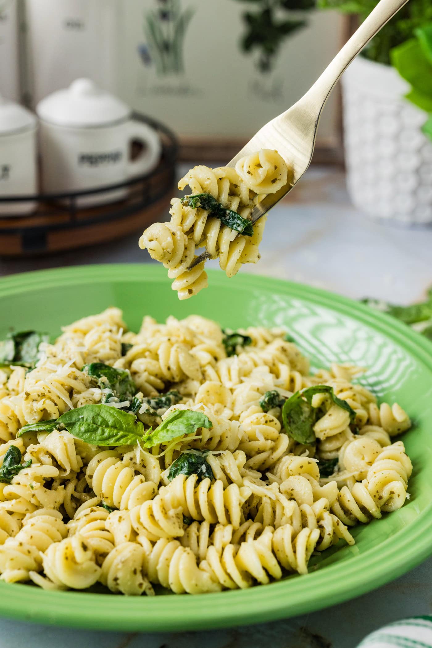 Forkful of Pesto Pasta held above a plate of Pesto Pasta