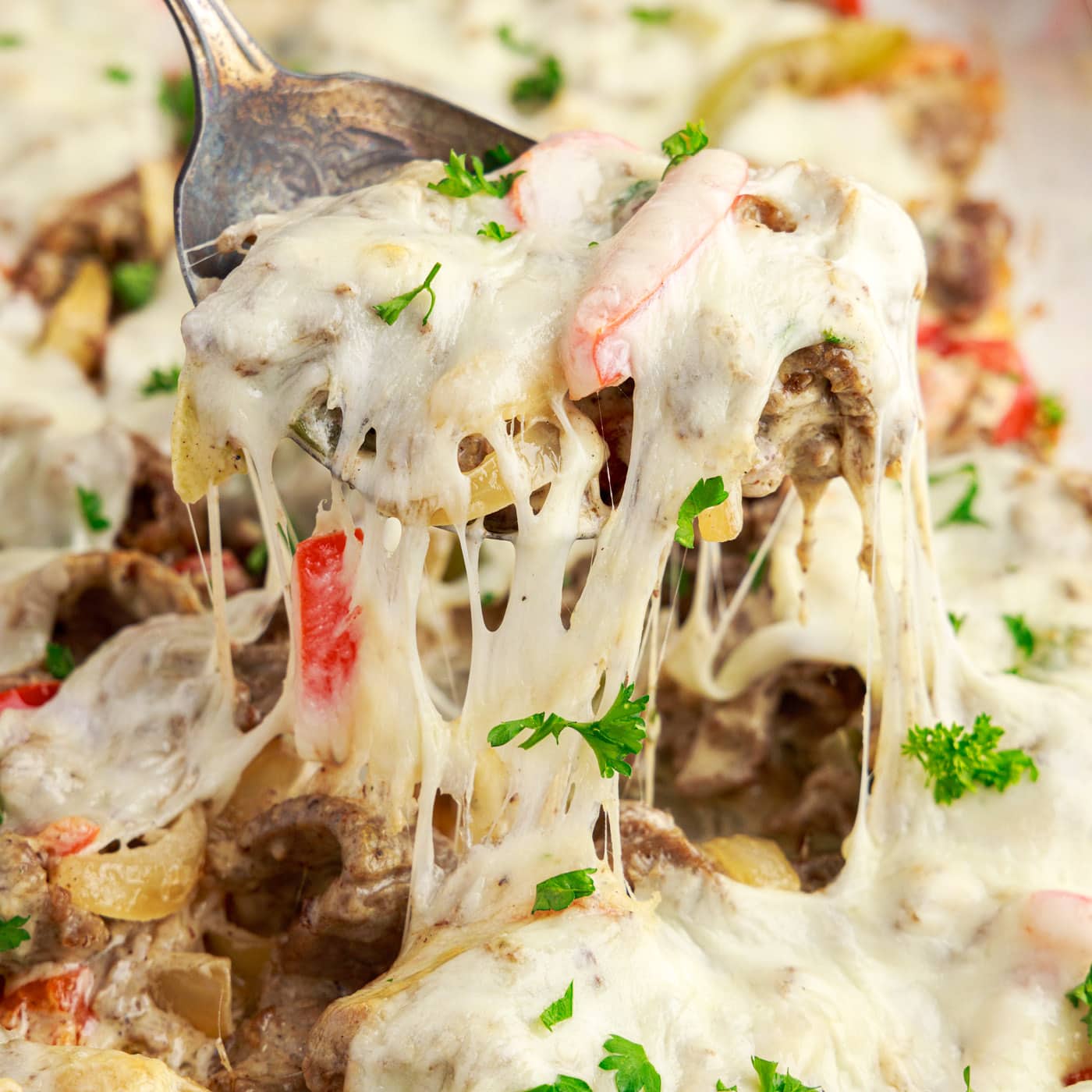 Spoonful of Philly Cheesesteak Casserole being lifted out of the pan