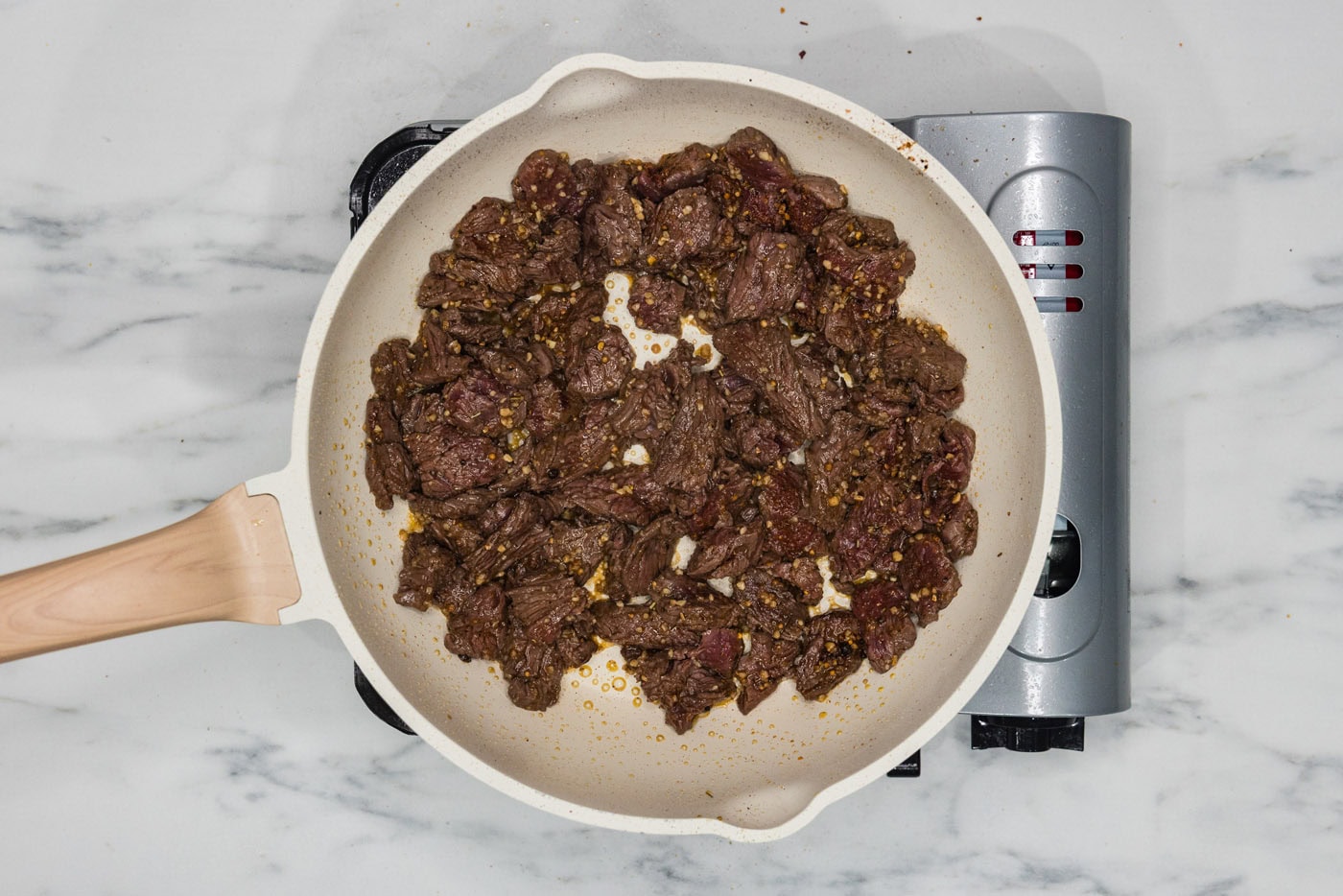 sliced steak and seasonings in a skillet