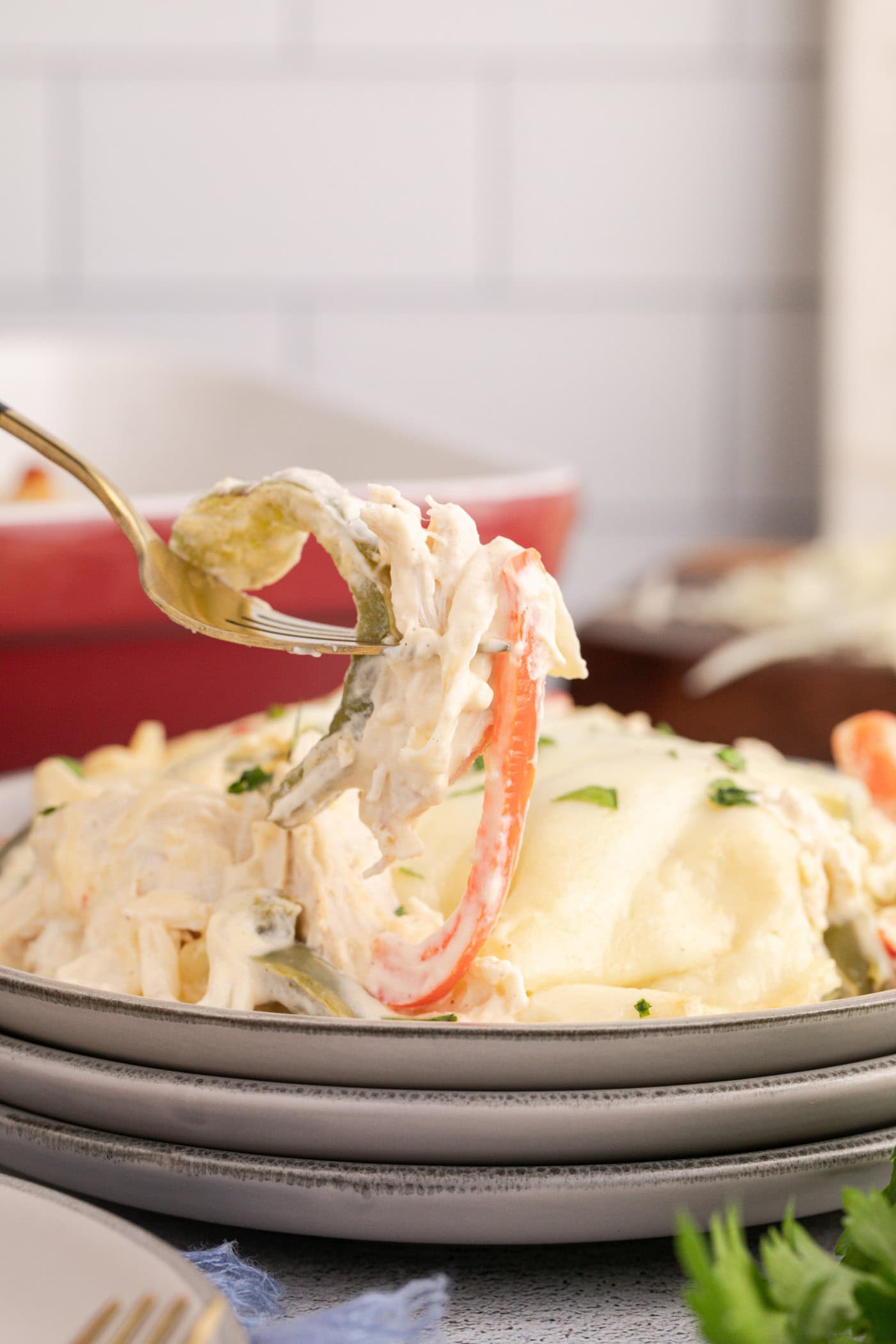Forkful of Philly Chicken Cheesesteak Casserole held above a plate