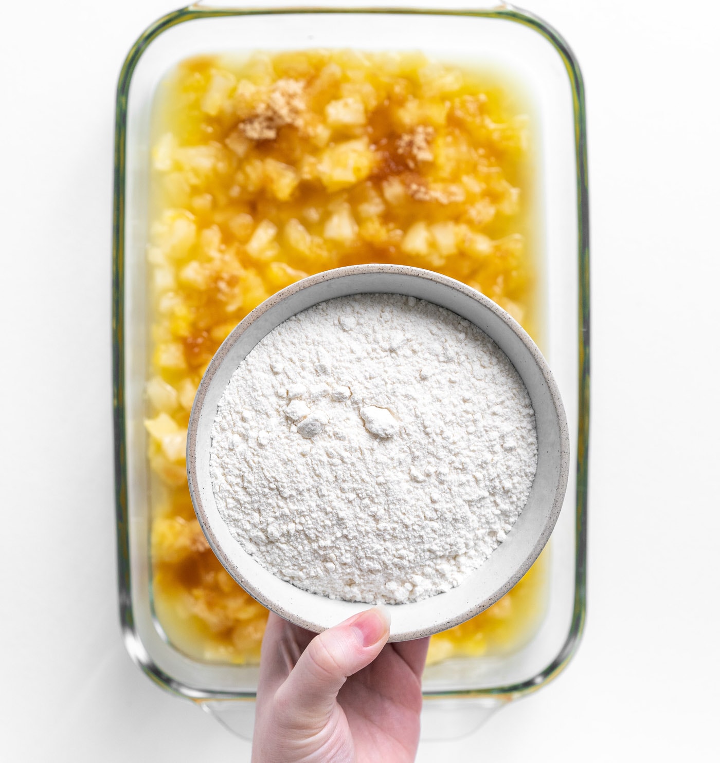 cake mix over crushed pineapple in a dish