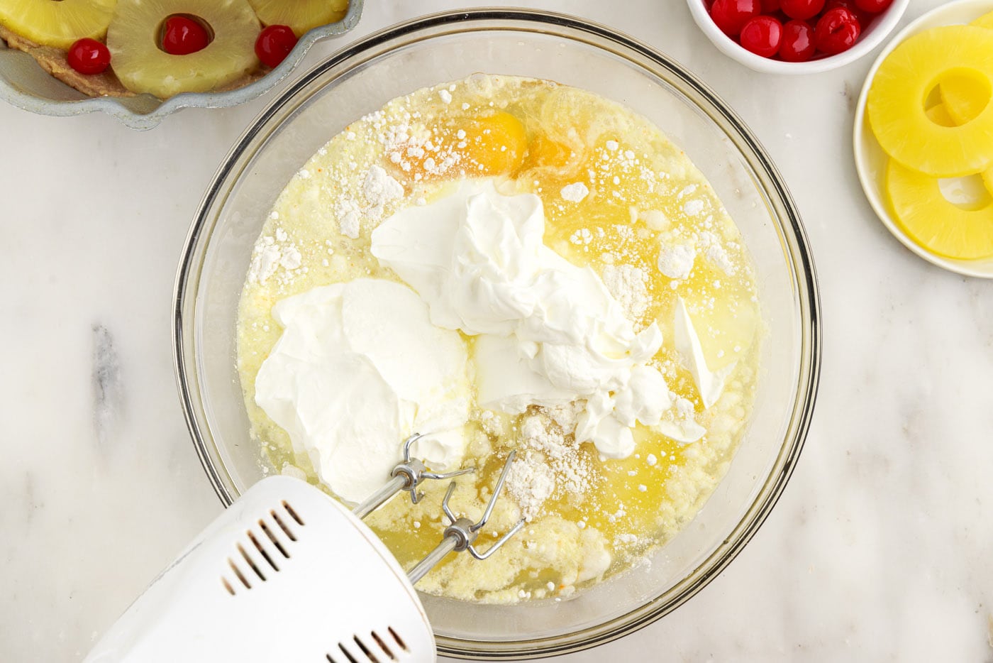 mixing bundt cake ingredients with a handheld mixer