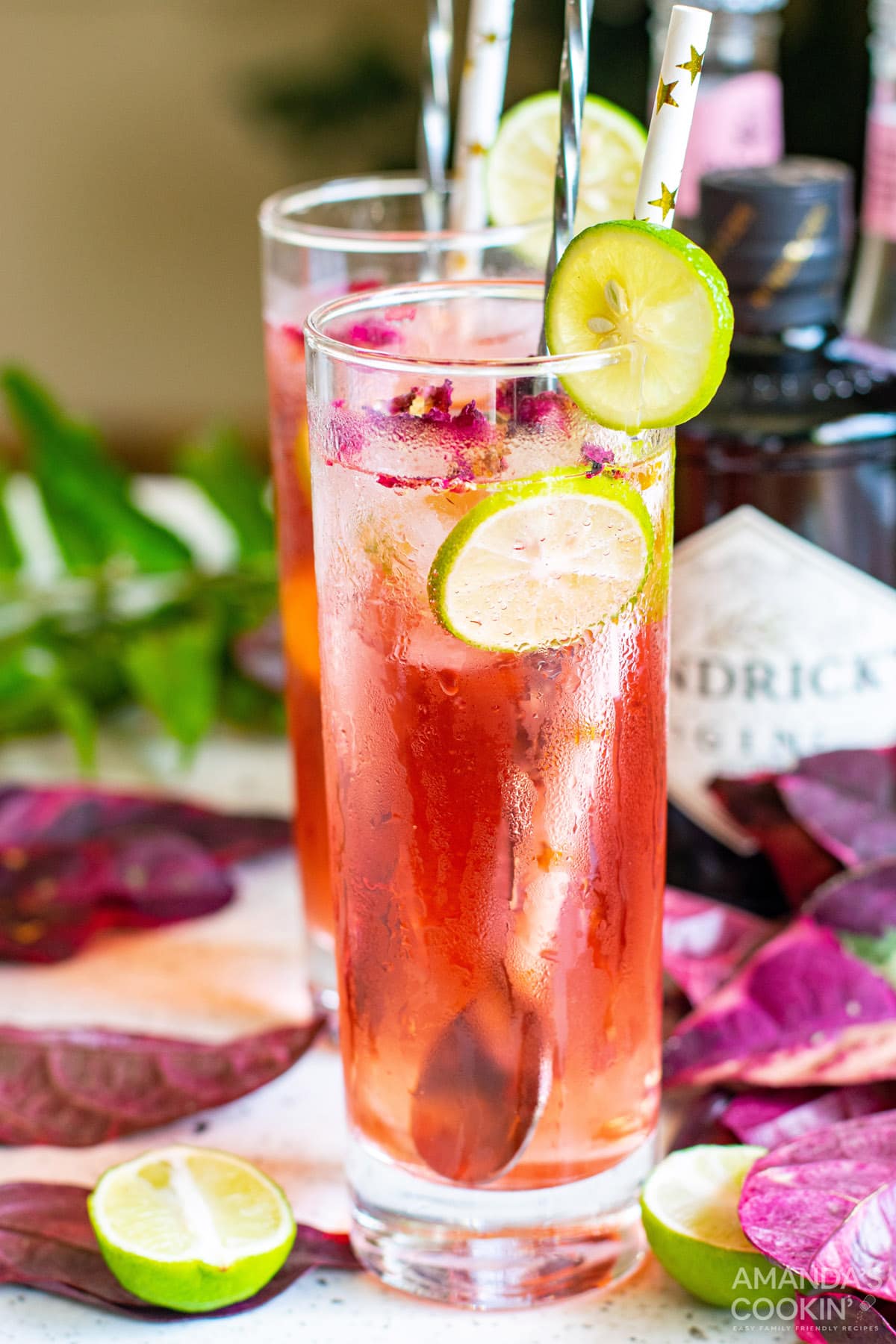 Pink Gin & Tonic with lime wedge and paper straw