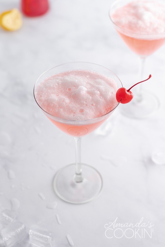 overhead view of frothy pink lady in martini glass