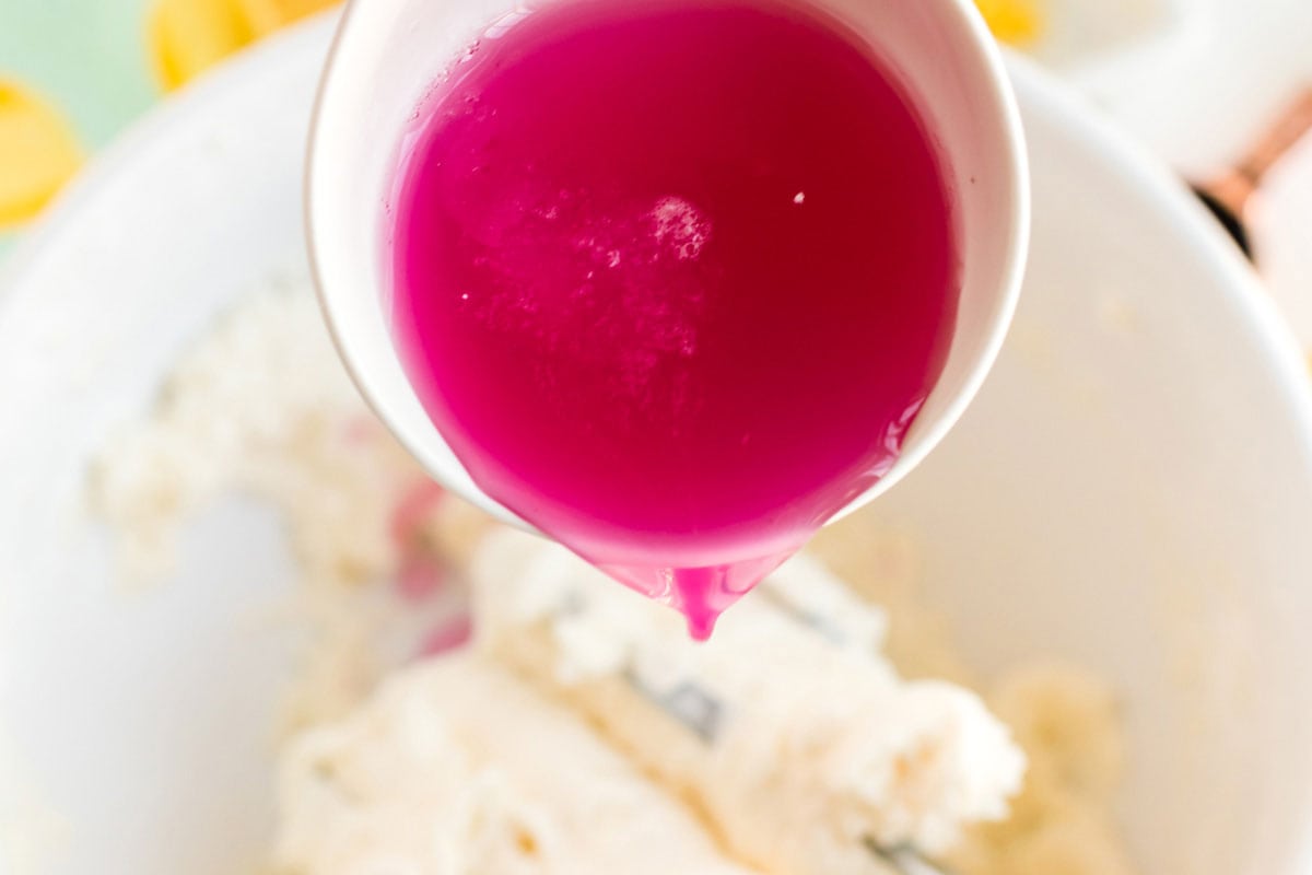adding pink lemonade concentrate to a bowl of cake batter
