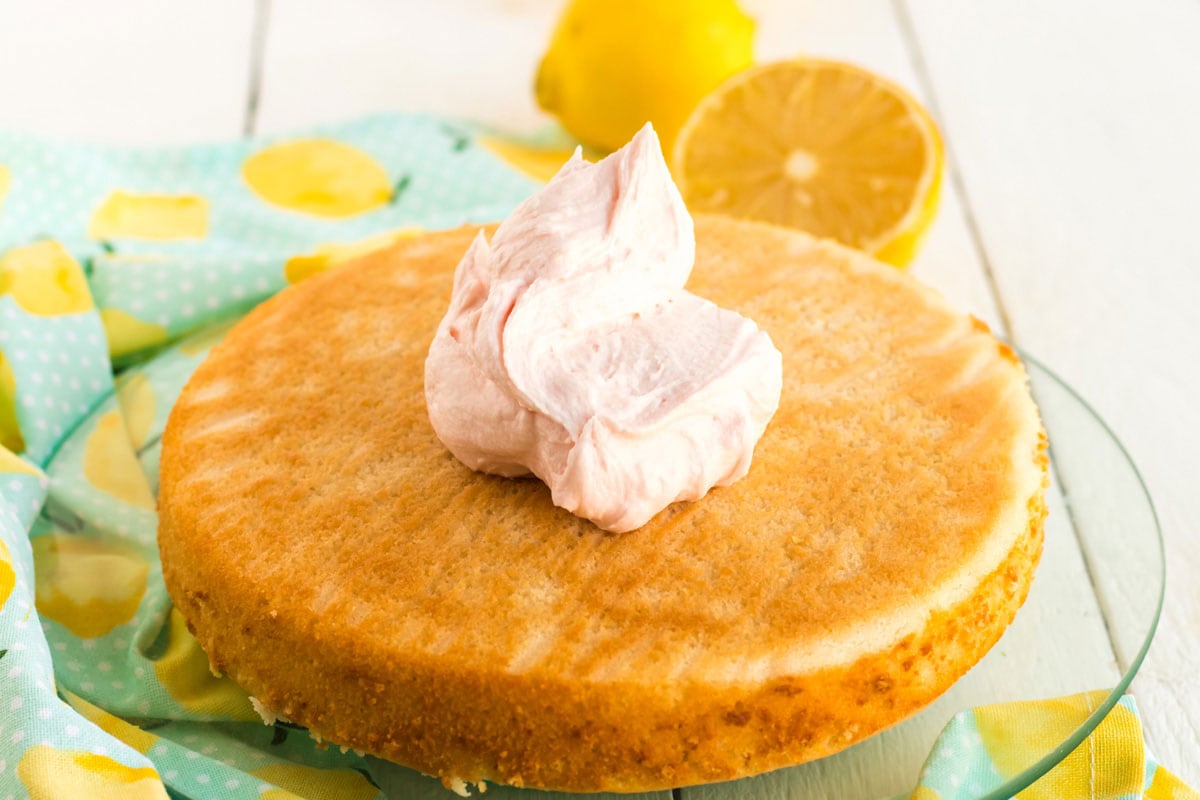 dollop of frosting on a layer of round cake