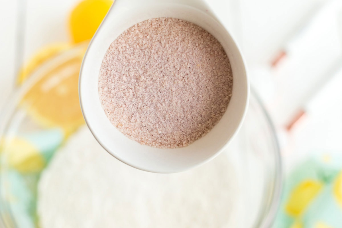 adding pink lemonade powder to bowl