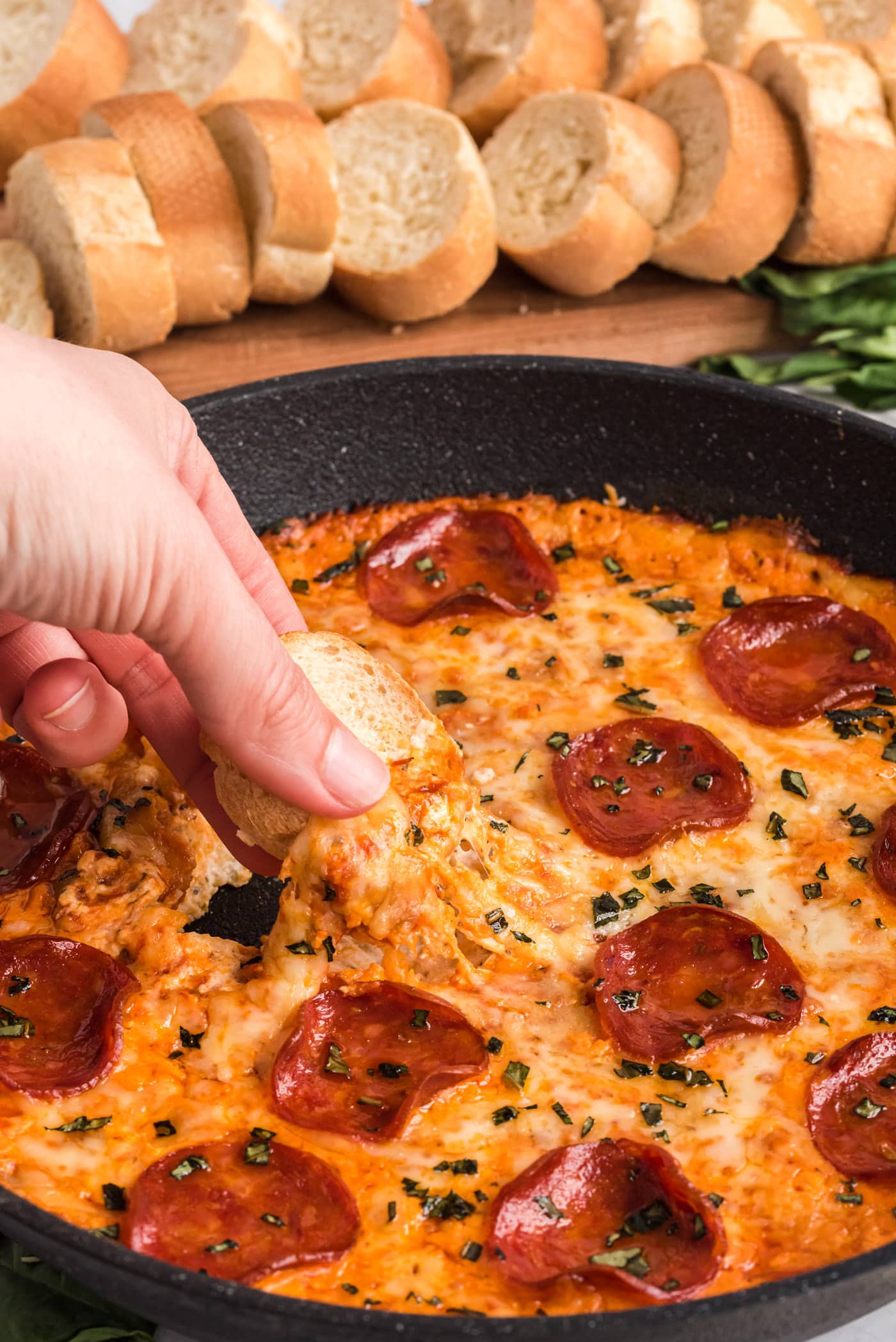 dipping bread into pizza dip
