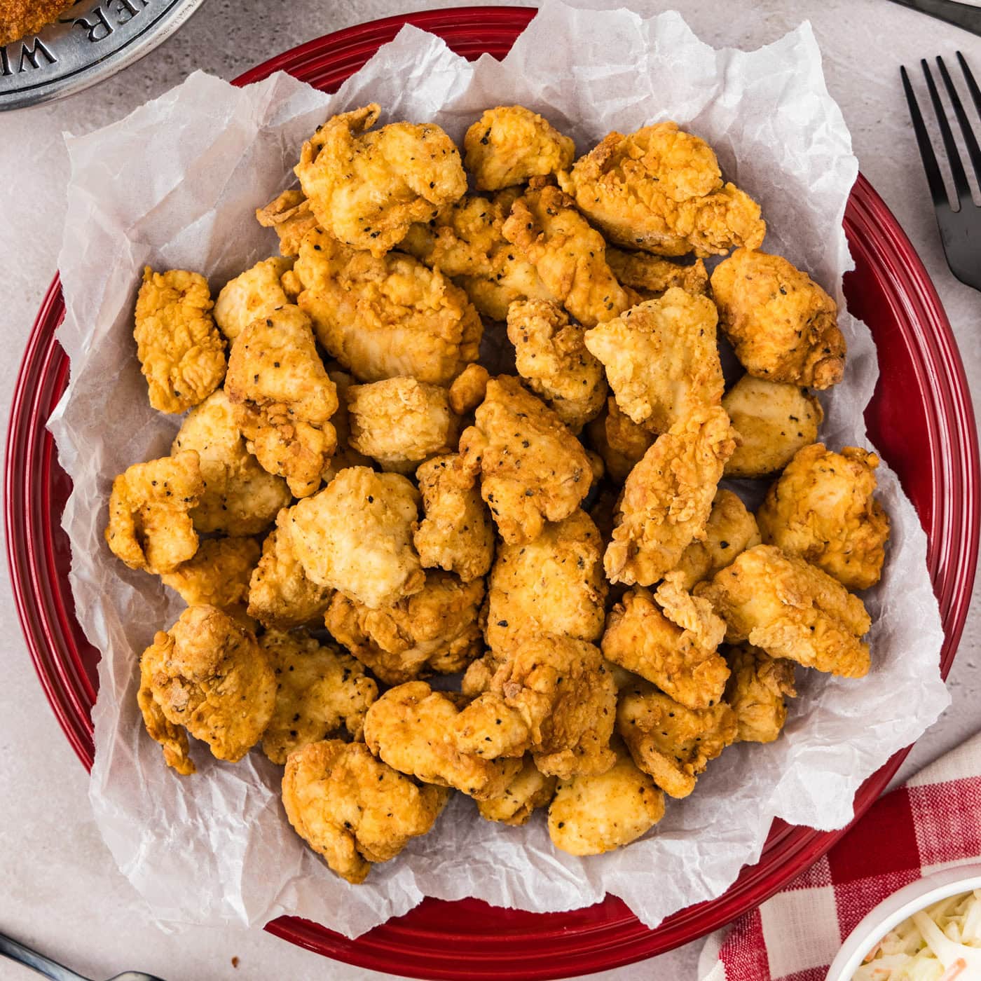 Close up photo of Popcorn Chicken on a parchment paper lined plate