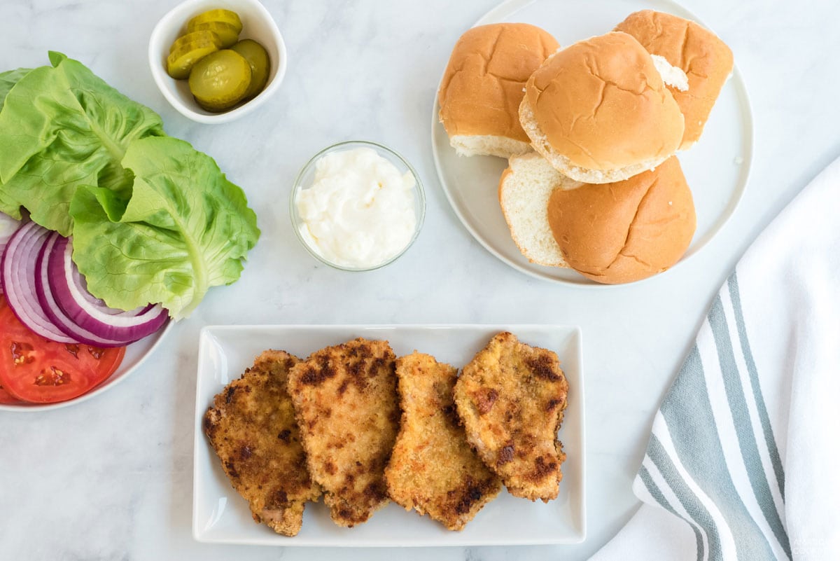 4 cooked breaded pork chops on a plate