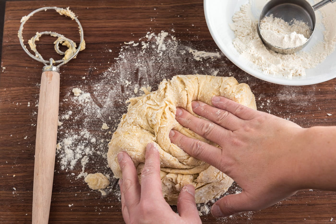 kneading dough ball on a floured surface